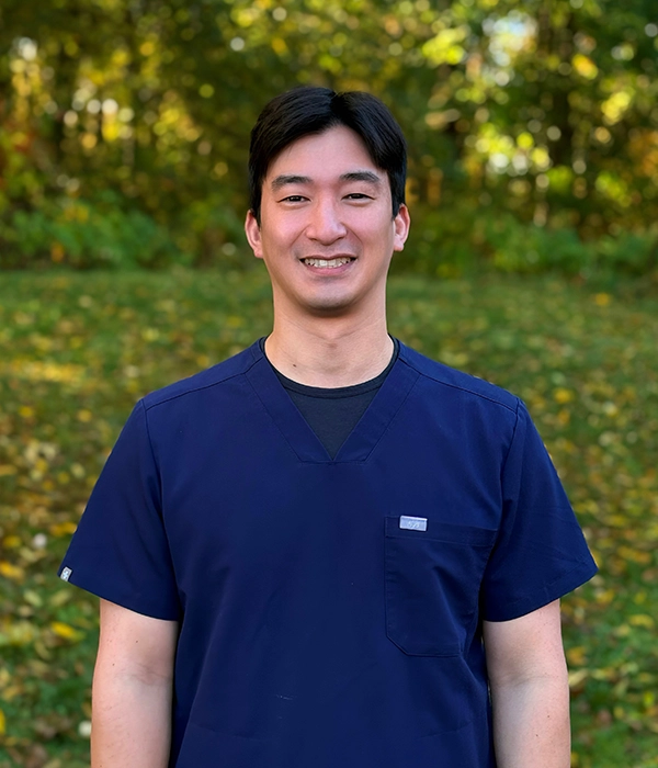 Dentist Joey Oh Smiling In Scrubs Outdoors In Nature