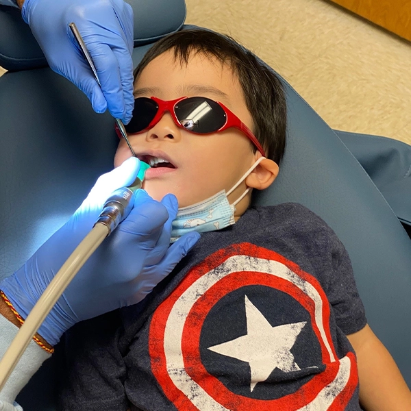 Little Boy In Red Sunglasses Receiving Dental Exam