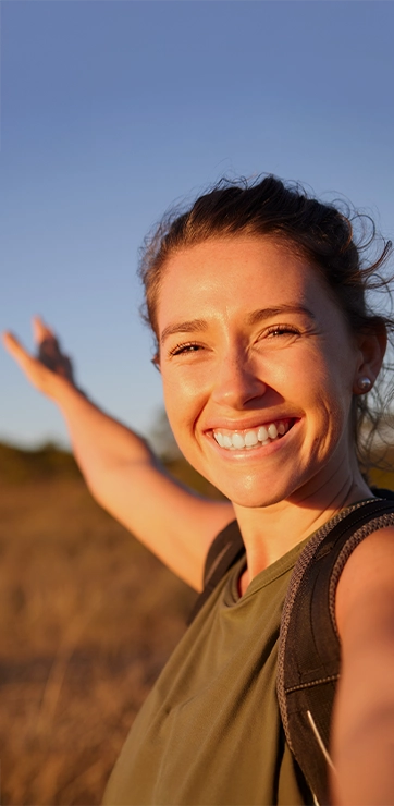 Woman Smiling And Hiking During Golden Hour